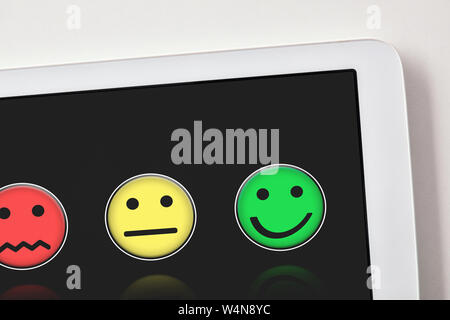 Soddisfazione dei livelli di rappresentazione con le emoticon con nero schermo tablet sul tavolo bianco vicino. Composizione orizzontale. Vista dall'alto. Foto Stock