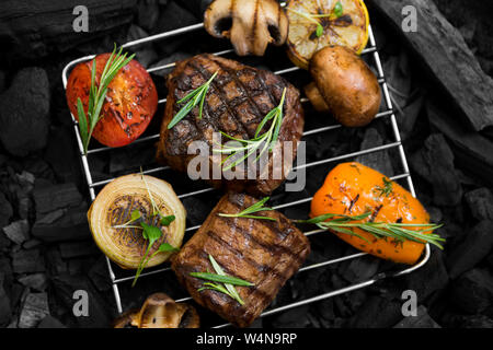 Ben fatto di carne con verdure alla griglia su griglia durante la cottura Foto Stock