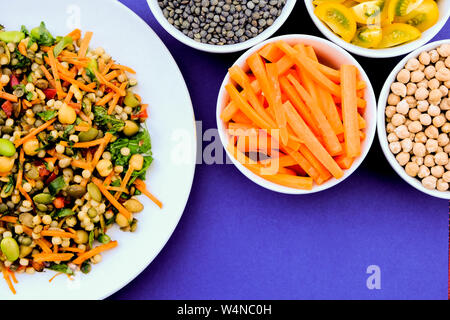 Vegetariano Insalata estiva con couscous e Edamame fagioli, lenticchie verdi, le carote e le erbe aromatiche Foto Stock