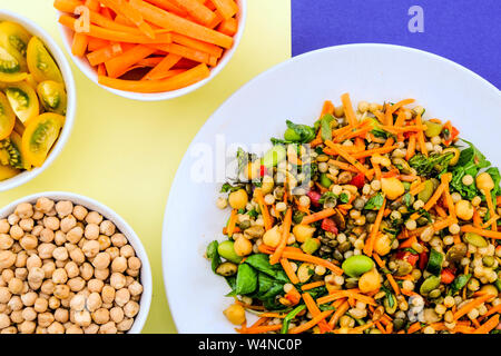 Vegetariano Insalata estiva con couscous e Edamame fagioli, lenticchie verdi, le carote e le erbe aromatiche Foto Stock