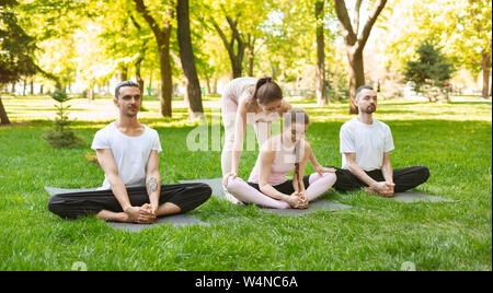 Personal trainer di yoga che aiuta a migliorare la flessibilità per il suo studente Foto Stock