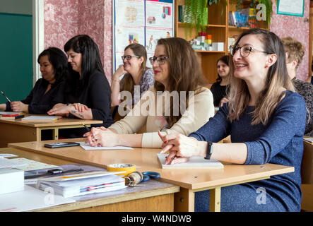 Gadjievo, Russia - 13 Aprile 2019: adulti nella classe della scuola siedono alle loro scrivanie. Foto Stock