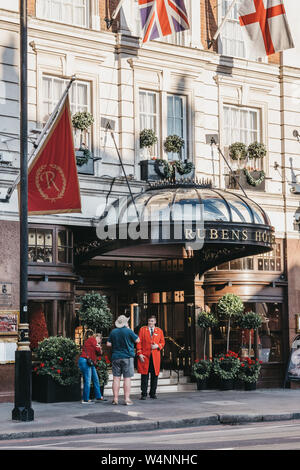 London, Regno Unito - 15 Luglio 2019: le persone a parlare con il maggiordomo al di fuori di Rubens al Palace, un hotel a 5 stelle situato nel centro di Londra con vedute del Foto Stock