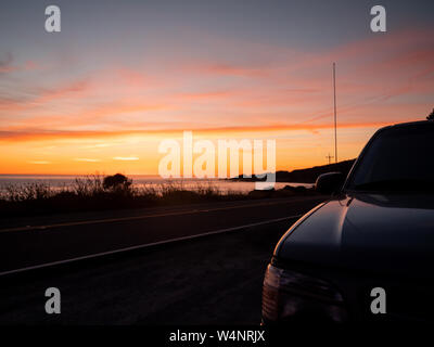 La parte anteriore della macchina sul lato della strada al tramonto Foto Stock