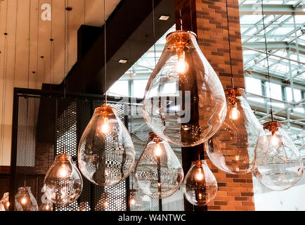 Gruppo di enormi lampadari in vetro con forma interessante nel centro commerciale per lo shopping. Foto Stock