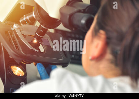 Immagine di scienziato con microscopio in laboratorio di analisi mediche Foto Stock