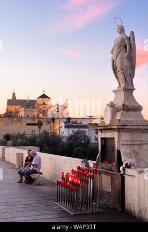 Sul ponte romano, un piccolo altare è spesso circondata da candele e fiori ospita una statua di Saint Raphael a Cordoba, Andalusia, Spagna Foto Stock