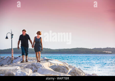 Croazia, Istria, giovane godersi il tramonto sul molo Foto Stock