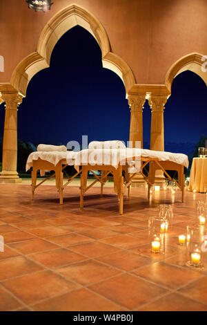 Massaggio tabelle impostato su un patio a lume di candela in un resort. Foto Stock