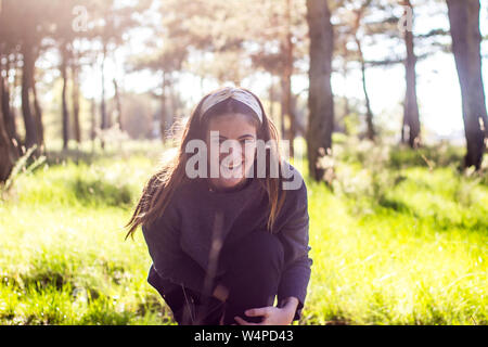 Ragazza sorridente nella foresta sulla natura al tramonto Foto Stock