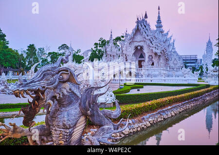 La statua di terribile drago di fossato, che è dugged attorno al bianco (tempio Wat Rong Khun), Chiang Rai, Thailandia Foto Stock