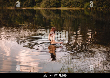 Donna che cammina nel lago Foto Stock