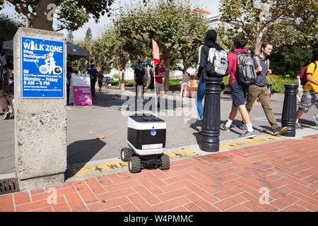 Un Kiwi cibo autonomo robot di erogazione dischi tra i pedoni che si prepara ad entrare Sather Road sul campus della UC Berkeley nel centro cittadino di Berkeley, California, il 9 ottobre 2018. () Foto Stock