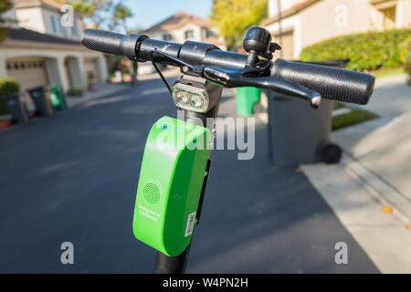 Close-up del manubrio e la centralina elettronica su un calce dockless scooter elettrici a San Ramon, California parcheggiato su un manto stradale in asfalto in una impostazione suburbane, 18 ottobre 2018. () Foto Stock