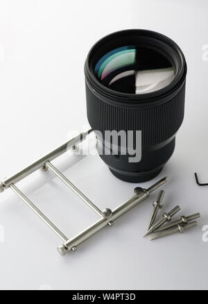 Manutenzione della lente digitale tema. Grande lente con chiavi attrezzi isolati Foto Stock