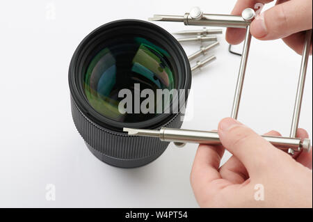 Il montaggio di lenti ottiche di tema con lo strumento chiave isolati su sfondo bianco Foto Stock