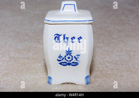 Blu Delft Tea (te) contenitore. Porcellana famosi souvenir da Holland/Paesi Bassi. Isolato su texture di sfondo beige. Foto Stock