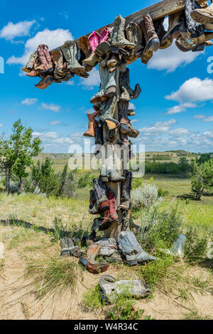 Vecchio stivali da cowboy appeso su un post in memoria di John Booth nel grande Sandhills in Saskatchewan, Canada Foto Stock