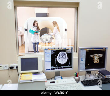 Macchina MRI e schermate con medico e infermiere Foto Stock