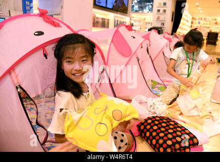 Qingdao, Cina Shandong. Il 24 luglio, 2019. Ragazze fanno il loro letto al primo piano di Zhanqiao Bookstore di Qingdao, est della Cina di Shandong, luglio 24, 2019. Durante le vacanze estive, Zhanqiao Bookstore tenutasi l'attività del sonno durante la notte presso il book store al fine di sviluppare buone abitudini di lettura per i bambini. Credito: Li Ziheng/Xinhua/Alamy Live News Foto Stock