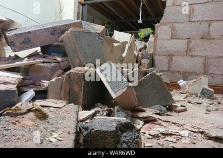 Demolita breeze blocco parete interna all'interno di una fabbrica. Parte di un progetto di ricostruzione. Sito di costruzione macerie Foto Stock