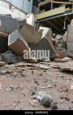 Demolita breeze blocco parete interna all'interno di una fabbrica. Parte di un progetto di ricostruzione. Sito di costruzione macerie Foto Stock