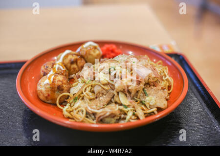 E takoyaki yakisoba in una piastra in un food court Foto Stock