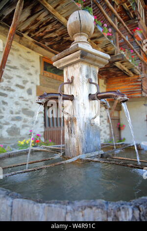 Close-up di un tradizionale fontana di legno si trova a Saint Veran village, Queyras Parco Naturale Regionale, Alpi del Sud, Francia Foto Stock