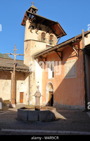 La piazza principale di Ceillac villaggio con un tradizionale fontana, San Sebastien Chiesa, Queyras Parco Naturale Regionale, Alpi del Sud, Francia Foto Stock