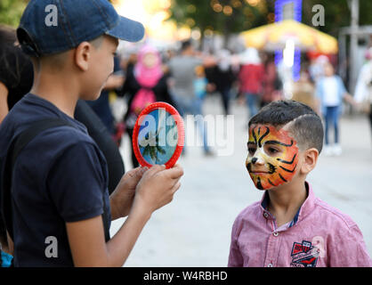 (190725) -- Damasco, luglio 25, 2019 (Xinhua) -- Un ragazzo che vede il suo riflesso in uno specchio durante un festival di intrattenimento denominato " ham (damasco) ci raduna' in Damasco, Siria, luglio 24, 2019. I mesi di durata del festival prevede esibizioni folcloristiche, giochi per bambini e degustazione del cibo tra le altre attività. (Foto di Ammar Safarjalani/Xinhua) Foto Stock