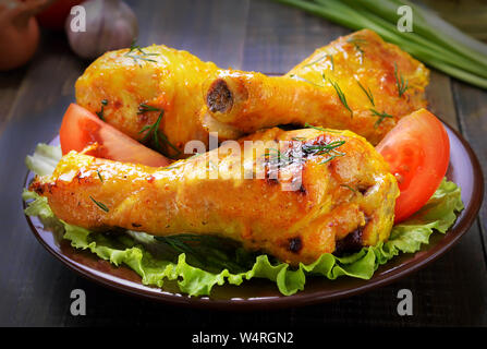 Il pollo al forno le gambe sul tavolo di legno, close up Foto Stock