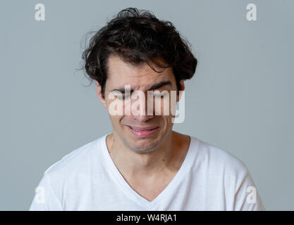 Ritratto di giovane uomo triste che grida nel dolore emotivo alla ricerca disperata e addolorato. Maschio millenaria che soffrono di depressione. In salute mentale e s Foto Stock