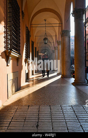 Giovane camminando lungo il colonnato, Bologna, Emilia Romagna, Italia Foto Stock
