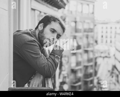 Triste Lonely Man staring al di fuori di casa balcone depressa angoscia e miserabile. Soffre di crisi emotiva pensando di difficile l importante Foto Stock