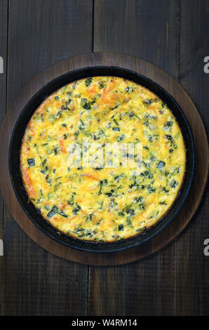 Frittata con erbe su sfondo di legno, vista dall'alto Foto Stock