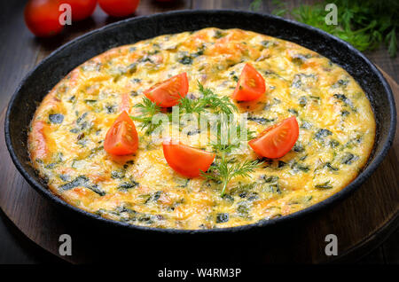 La frittata in padella sul tavolo di legno, close up Foto Stock