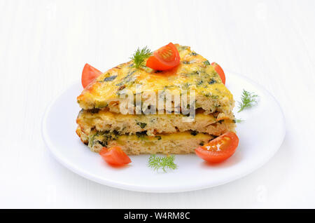 Pezzo di frittata di verdure sulla piastra bianca Foto Stock