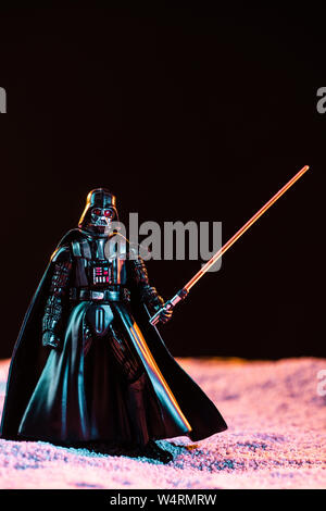 Kiev, Ucraina - 25 Maggio 2019: Darth Vader figurine con spada laser isolato su nero Foto Stock