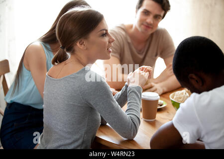 Attraente Excited donna di condividere idee con razza mista migliori amici. Foto Stock