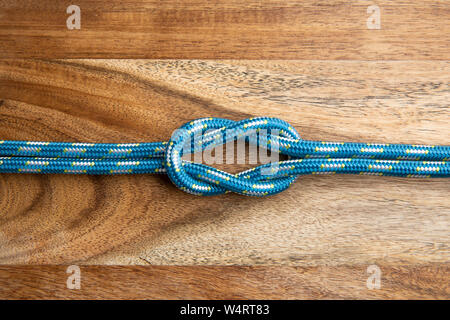 Nodo quadrato. Cima nautica nodo sullo sfondo di legno Foto Stock