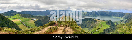 Coppia giovane godere la vista panoramica del cratere Sete Cidades da Pico da Cruz a Sao Miguel, Azzorre Foto Stock