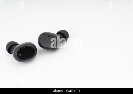 Gli auricolari wireless o auricolari su sfondo bianco Foto Stock