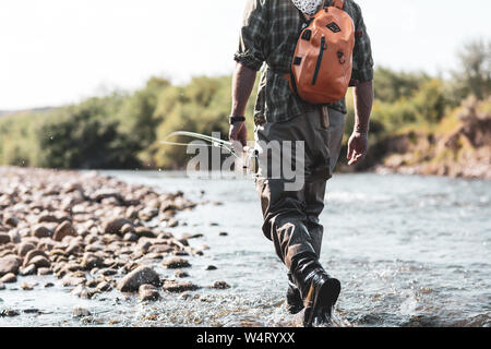 Fly fisherman camminando nel fiume, Wyoming negli Stati Uniti Foto Stock