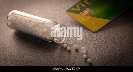 Colore moderno pillole omeopatici in contenitore di plastica su sfondo nero, Francia Foto Stock