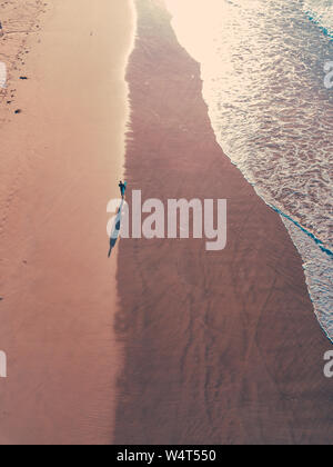 Vista aerea di un uomo a camminare lungo la spiaggia di tredicesima, Melbourne, Victoria, Australia Foto Stock