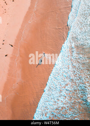 Vista aerea di un uomo a camminare lungo la spiaggia di tredicesima, Victoria, Australia Foto Stock