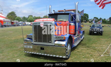 Planet Circus autocarro nei colori del trasformatore Autobot Optimus Prime, con Decepticon Barricata, a Torre Abbey, Torquay, Devon, Inghilterra, Regno Unito. Foto Stock