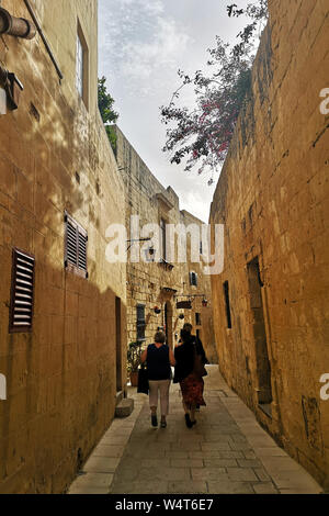Tre persone che camminano per le strade di Medina, Malta Foto Stock