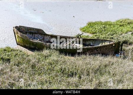 Un abbandonato e fatiscente barca ormeggiata in canneti del fiume Torridge a bassa marea a est l'acqua, Bideford, Devon, Regno Unito Foto Stock