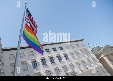 Berlino, Germania. Xxv Luglio, 2019. Una bandiera arcobaleno si blocca sotto una bandiera statunitense presso l ambasciata degli Stati Uniti. La quarantunesima Berlin Christopher Street Day avrà luogo sabato 27 luglio. Credito: Jörg Carstensen/dpa/Alamy Live News Foto Stock